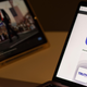 A laptop screen showing the App Store preview for Truth Social sitting next to a tablet screen with a blurred image of Donald Trump.